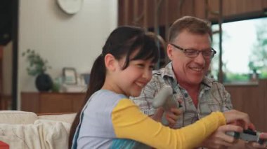 Büyükbaba ve torun birlikte konsol oyunu, eğlence medyası oynuyorlar. Eski kullanım teknolojisi yeni nesil ile iletişim kurar. Nesiller arası uçurum aile bağını güçlendirir. Uyumsuzluk.