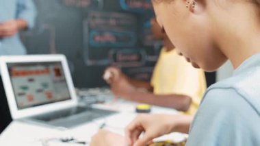 Öğretmenler kodlama sistemini öğretirken, farklı akademik öğrenciler STEM teknoloji sınıfında ana tahtayı dizüstü bilgisayar programlama programlama veya mühendislik kodu ile düzeltiyorlar. Öğretim