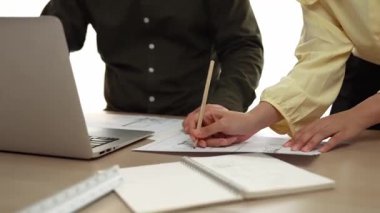 Mimar ve mühendis, modern ofisteki tablo üzerinde tasarım, ölçüm aracı ve plan için dizüstü bilgisayardaki taslak ayrıntılı taslak ile el yazısını karşılaştırıyor. - Yakın çekim. Tanımlama.