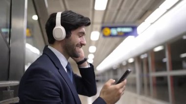 Tren istasyonunda geçmişi bulanık bir şekilde beklerken kulaklıkla müzik dinleyen zeki bir iş adamı. Yetenekli proje yöneticisi cep telefonu tutarken dinlenme sesi dinlemeyi sever. Sevinçli..