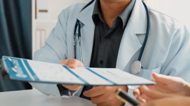 Hastane masasında birlikte çalışan ve tıbbi tedavi planlayan çeşitli profesyonel sağlık görevlileri. Takım çalışması başarılı hastalıklara ve hastalıklara yol açar. Ağır çekim. Katı.