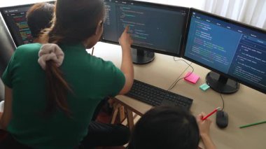 Yavaş çekim arkası yazılım geliştirici mühendisi bilgisayar programlama için birlikte çalışarak hata ayıklama kodunu çözüyor, ofiste monitörde karmaşık algoritmaları çözüyor. Filizlenen