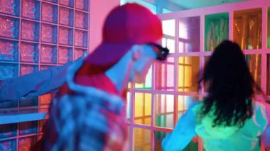 İspanyol hipster, gece kulübü neon ışığında dans yeteneğini sergilerken break dansçı dans yapıyor. Zeki hipster serbest stil müziğe geçiyor ve hareketli bir ruh hali içinde ayak sesleri çıkarıyor. Yaşam tarzı. Mutluluk.