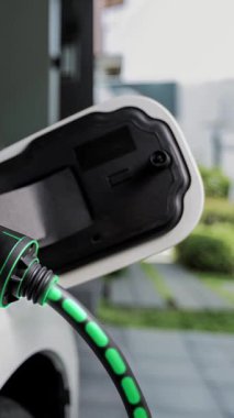 Elektrikli araba, gelecekteki ev şarj istasyonunda akıllı dijital EV batarya durumu hologramıyla şarj oluyor. EV arabasının teknolojik gelişimi ve sürdürülebilir gelecek için ev enerjisi altyapısı. İncelenme