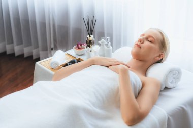 Kafkasyalı kadın müşteri stres önleyici spa masajının keyfini çıkarıyor ve lüks otel ya da oteldeki gündüz açık ortam güzellik salonunda güzellik teniyle eğleniyor. Sessiz.