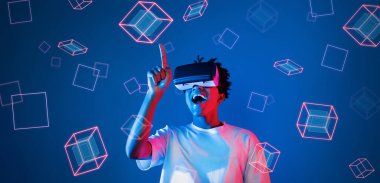 Geometrik şekillerde süzülürken mavi arka planda duran zeki çocuk. Afrikalı bir adam oyun oynuyor, VR gözlük takıyor ve sıradan bir gömlek giyiyor. Gelişmiş gerçeklik teknolojisi yenilik kavramı. Yaratıcılık.