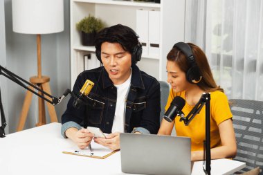 Gülümseyen radyo etkili sunucular, kulaklık takıp sosyal medyayı canlı yayında dinleyicilere telefon ve dizüstü bilgisayarla canlı yayınlıyorlar. İnfobahn.