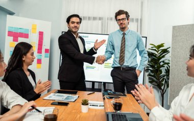 Gururlu patron ya da girişimci, çeşitli etnik ofis çalışanlarını teşvik etmek ve motive etmek için başarılı bir satış veya pazarlama planı yaptıktan sonra çalışanına övgüde bulunuyor. Habiliment