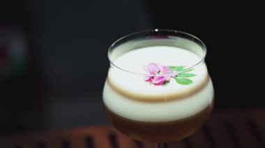 Tutkulu meyve suyu bardağında dönüşümlü, özel, ferahlatıcı, pembe çiçekle süslenmiş, lüks gece klübünde gece hayatı karışımı sergilenen bir içecek. Vinosity.