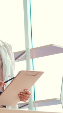 İki iş adamı toplantı odasında proje stratejisi hakkında konuşuyor. İş adamı, mali veri raporu hakkında sohbet ve tavsiyelerde bulunurken, modern işyerindeki iş arkadaşıyla proje planlamasını tartıştı.