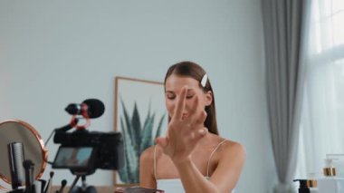 Sosyal medya için güzellik ve kozmetik video içeriği hazırlayan genç bir kadın. Güzellik blogcusu kameraya gülümserken seyircilere ve takipçilere güzellik bakımını gösteriyor. Düzenle