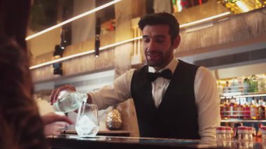 Lüks barlarda cin kokteyli ya da tonik servisi yapan akıllı barmenlere odaklanırken, arka plandaki VIP müşterilerle sıcak gece kulübünün ışıklandırma atmosferinde canlı sohbetler yapıyorlar. Vinosity.