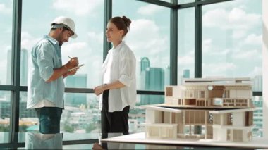 Ev modelinin yanında duran yetenekli mimar mühendis takımı tartışması. Bir grup zeki iç mimar not alıyor ve paylaşıyor, beyin fırtınası yapıyor, bina tasarımı hakkında düşünüyor. İzleme