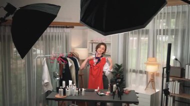 Kadın nüfuzlu kişi video görüntülerini canlı yayınlıyor. Kıyafetler sosyal medyada ya da blogda yer alıyor. Stüdyo ışıklandırmalı mutlu genç kız çevrimiçi pazarlama oturumu yayını için..