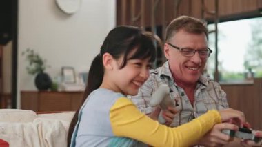 Büyükbaba ve torun birlikte konsol oyunu, eğlence medyası oynuyorlar. Eski kullanım teknolojisi yeni nesil ile iletişim kurar. Nesiller arası uçurum aile bağını güçlendirir. Uyumsuzluk.