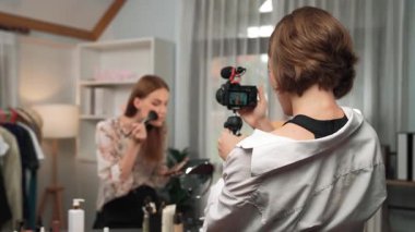 Etkilenen iki ortak canlı yayında video görüntülerini çekiyor makyaj malzemesi prim sosyal medya veya blog. Kozmetik stüdyosu ışıklandırmalı mutlu genç kız çevrimiçi pazarlama oturumu yayını için..