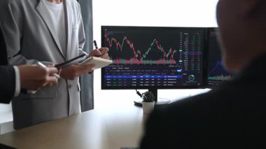 Hisse senedi borsası pazarlamasını analiz eden yavaş çekim şirketindeki yatırımcılar, kayıp için mum bar fiyatını analiz eden monitörlere bakıyor ve kazanç ve kâr elde ediyor. Filizlenen