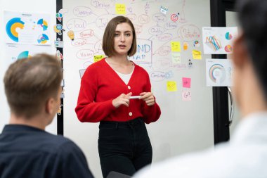 Profesyonel çekici kadın lider, modern iş toplantı odasında beyin fırtınası zihin haritalama istatistikleri ve renkli yapışkan notlar kullanarak yaratıcı pazarlama planını sunuyor. Tertemiz..