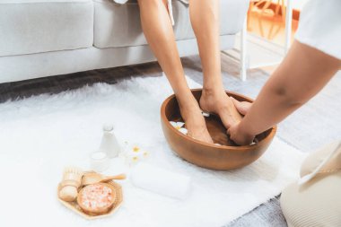 Kadınlar lüks spa salonlarında keyifli ayak masajlarına devam ederken, masör de hafif gün ışığı atmosferinde refleksoloji terapisi veya otel ayak spa 'sında. Sessiz.
