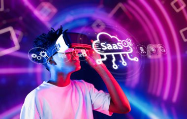 Genç bir birey, canlı renkler ve modern yenilikleri sergileyen bir hizmet olarak yazılım kavramını gösteren dijital elementlerle çevrelenmiş sanal gerçekliğe dalmıştır. XDMCP