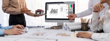 İç mimar tasarımcı grubu, daha kesin tasarım için planlar ve dizüstü bilgisayar ekran mimari yazılımı üzerinde birlikte tartışıyorlar. Modern ev tasarımı ve yenileme. İçgörü