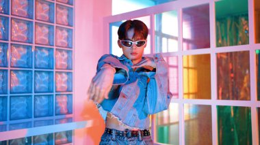 Ortasında dans eden profesyonel mutlu hipster onu alkışlayan çeşitli arkadaşlarıyla dans ediyor. Çekici Asyalı kırığı gece kulübünde neon ışığıyla enerjik adımlar atıyor. Mutluluk.