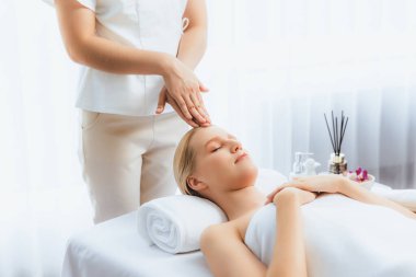 Kafkasyalı kadın stres önleyici kafa masajından ve lüks tatil beldesi ya da otel spa salonundaki modern ışık ortamında yüz güzelliği eğlencelerini şımartmaktan hoşlanıyor. Sessiz.