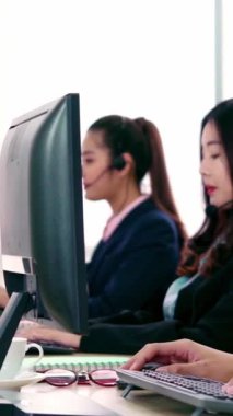 Ofiste çalışan kulaklık takan işadamları uzak müşteri ya da meslektaşlarını desteklemek için çalışıyorlar. Arama merkezi, tele pazarlama, müşteri destek acentesi telefon görüşmesinde hizmet sunar.