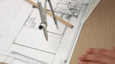 Bölücü araç ve el yazısı kullanan akıllı mimar ya da güvenlik mühendisinin videosu mimari ofisteki inşaat doğruluğu planının ayrıntılarını içeriyor. Eline odaklan. - Yakın çekim. Tanımlama.