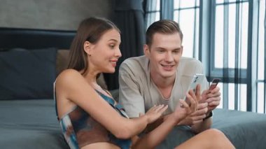 Genç çift, online ödeme uygulaması ve dijital cüzdanı kullanarak kredi kartıyla ödeme yaptıktan sonra mutlu ve heyecanlı hissediyorlar. Mobil internet üzerinden alışveriş ve modern alımlar. Düzenle