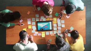 Yazılımcının web tasarımı hakkında beyin fırtınası yapması ve planlaması tablet kablo prototipine bakarken zaman aşımı. Yetenekli müteahhit takımının dijital uygulamadan bahseden hava görüşü. Sempozyum.