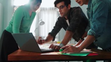 Dizüstü bilgisayara bakan ve logo tasarımını işaret eden yetenekli bir iş ekibi ana tema rengini seçme ve pazarlama kampanyasını planlama kararı alıyor. Birlikte çalışan akıllı bir grup. Sempozyum.