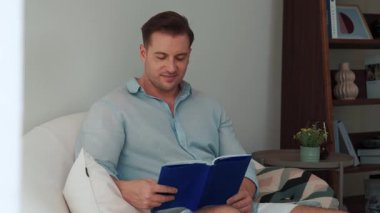 Kanepede oturan orta yaşlı bir adam, sosyal ve teknolojik mesleki gelişmeler hakkında ders kitabı okur ya da çocukları iyi bir yetişkin baba olmak için yetiştirir. Hayat boyu öğrenme konsepti. Uyumsuzluk.