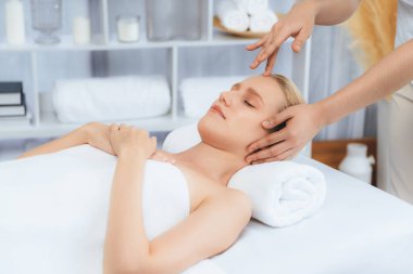 Kafkasyalı kadın stres önleyici kafa masajından ve lüks tatil beldesi ya da otel spa salonundaki modern ışık ortamında yüz güzelliği eğlencelerini şımartmaktan hoşlanıyor. Sessiz.