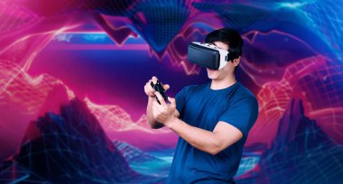 Profesyonel oyuncu, elinde pembe ve mor gradyan arka planda joystick tutarken VR kulaklık takıyor. Gelişigüzel giyinen yetenekli bir oyuncu ve arka planda artırılmış gerçeklik teknolojisi kullanıyor. Yaratıcılık.