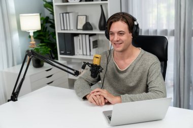 Sunucu kanalı, gülümseyen akıllı yayıncı kaydı, senaryosu ve akıllı telefonuyla sosyal medyada sohbet programı, kulaklık takarak modern ev stüdyosundaki video flamalarını kaydediyor. Bireysel.