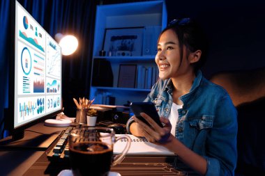 Gülümseyen genç, güzel Asyalı yaratıcı satış hedefi raporunun kar tablosuna bakıyor ve notlar üzerine notlar yazarak neon ışığı gecesinde yeni bir strateji pazarı projesine yatırım yapmayı planlıyor. Taktik.