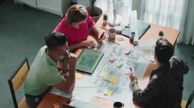 Ev inşaatını planlamak için birlikte çalışan mimar mühendis ekibinin üst görüşü. Profesyonel iş konuşmaları ve toplantı odasında inşaat veya ev inşaatı hakkında tartışmalar. Sempozyum.