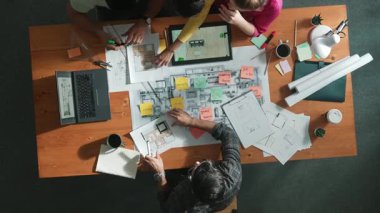 Pazarlama ekibi tasarım planlarken yöneticinin planlarını yukarıdan aşağıya incelemek. Mimar mühendisin birlikte çalıştığı, fikir paylaştığı ve proje planına not aldığı hava görüşü. Sempozyum.