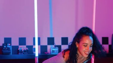 Stüdyoda mor ışıkla sokak dansı yapan İspanyol sokak dansçılarına yakın çekim. Profesyonel sanatçı şık kumaşla enerjik bir hareket sergiler. Çılgın, komik. Yarı vücut. Mutluluk.