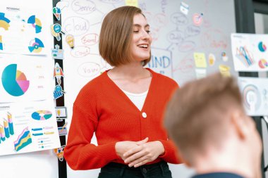 Profesyonel çekici kadın lider, modern iş toplantı odasında beyin fırtınası zihin haritalama istatistikleri ve renkli yapışkan notlar kullanarak yaratıcı pazarlama planını sunuyor. Tertemiz..