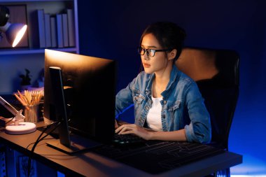 Genç, Asyalı yaratıcı bir kadının satış hedefi raporundan elde ettiği karı analiz etmesi, e-posta ile iş piyasası raporlarını karşılaştırması, gece neon ışığı altında not defterine not yazması. Taktik.