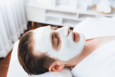 Kaplıca salonunun sakin atmosferi, insan müşterisi modern gün ışığında lüks yüz kremi masajıyla kendini yenileme zevkine kapılıyor. Yüz bakımı ve güzellik konsepti. Sessiz.