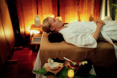 Aromaterapi masajı ambiyansı ya da spa salonu kompozisyon düzeneği bulanık kadınlara odaklı dekor mumları ve spa aksesuarları ile tatil köyü veya otel arka planında keyifli aroma spa masajı yapan. Sessiz.