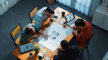 Yaratıcı ekibin satışları ya da başarılı fikirleri kutlamak için beşlik çakması. Çeşitli insanlardan oluşan bir grup, el çırparken yapışkan bir notla pazarlama planı yapıyor..