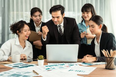 Kutlama jesti ve başarılı takım çalışması yapan bir grup mutlu iş adamı. Çeşitli yarış bürosu çalışanları şirket ofisinde pazarlama planlamasında ilerleme kaydettikten sonra kutlama yapıyorlar. Habiliment