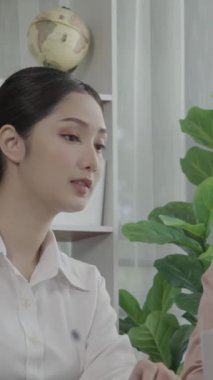 Ofis çalışma alanında birlikte çalışan iki genç hevesli iş kadını. Genç meslektaşlar tartışırken ve dizüstü bilgisayar kullanırken. Modern ofis çalışanları masada birlikte oturuyorlar..