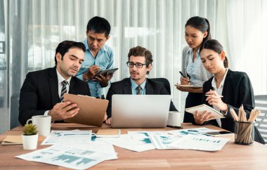 Ofis masasındaki finansal veri raporlarını analiz eden çeşitli bir grup iş analisti. Stratejik pazarlama planlaması için iş istihbarat analizine göre grafikler ve grafikler.