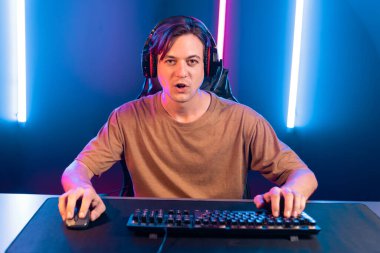 Kazanmak için çevrimiçi oyun oynayan akıllı flama makinesinin sunucu kanalı, neon ışıklı odada seçilen takım yarışması için izleyicilerle birlikte canlı yayında canlı yayında kulaklık takıyor. Bireysel.