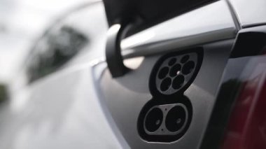 EV şarj prizi kapağı elektrikli arabaya bağlanıyor, EV araba aküsünü temiz çevre için sıfır CO2 emisyonu ile alternatif ve sürdürülebilir enerjiyle şarj ediyor. Titiz